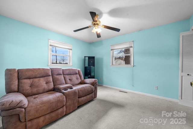 carpeted living room featuring visible vents, baseboards, and ceiling fan