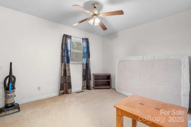 interior space with carpet flooring, ceiling fan, visible vents, and baseboards