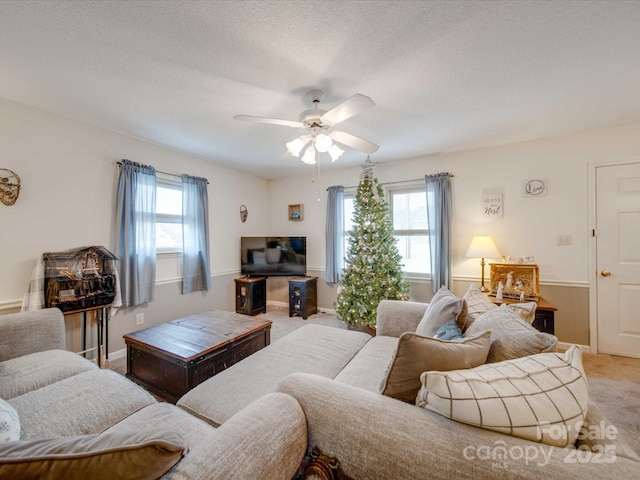 living room featuring ceiling fan, plenty of natural light, carpet floors, and a textured ceiling