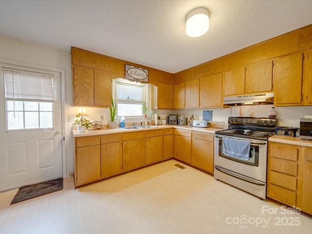 kitchen featuring sink, stainless steel electric range, and a textured ceiling