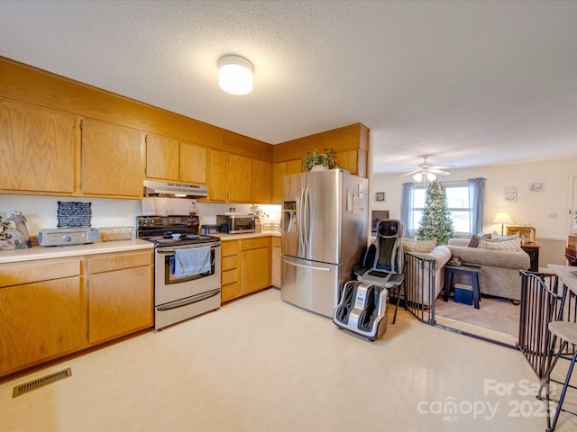 kitchen with ceiling fan, stainless steel appliances, and a textured ceiling