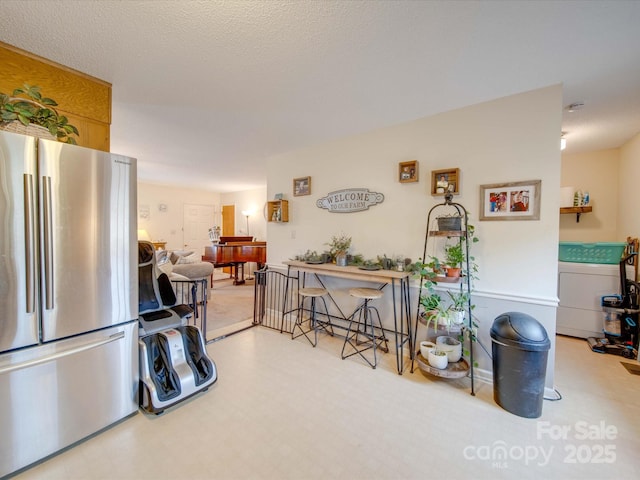 kitchen with a textured ceiling and stainless steel refrigerator