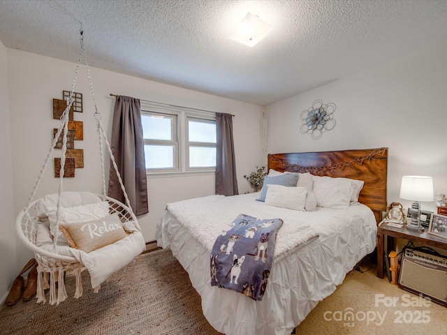 bedroom with baseboard heating, a textured ceiling, and carpet