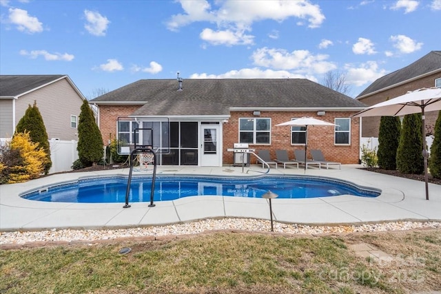 view of pool with a sunroom, area for grilling, and a patio area