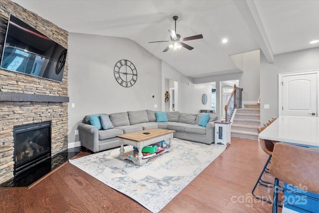 living room with vaulted ceiling, dark hardwood / wood-style flooring, ceiling fan, and a fireplace