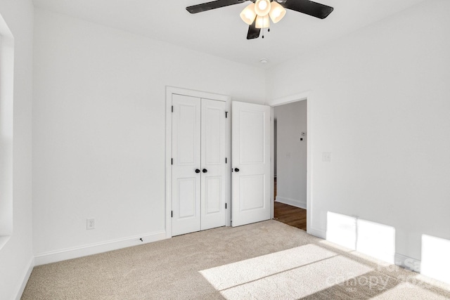 unfurnished bedroom with light carpet, ceiling fan, and a closet