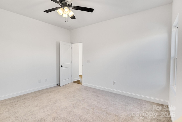 empty room featuring ceiling fan and light colored carpet