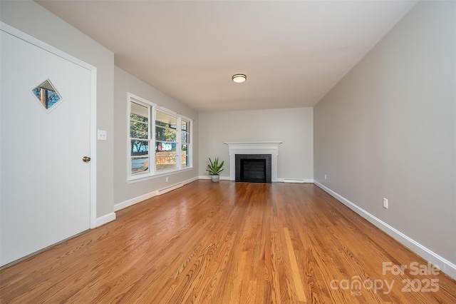 unfurnished living room with a fireplace and light hardwood / wood-style flooring