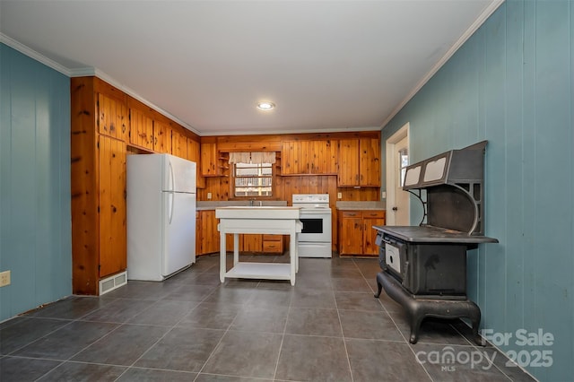 kitchen featuring crown molding, white appliances, a kitchen island, and dark tile patterned floors