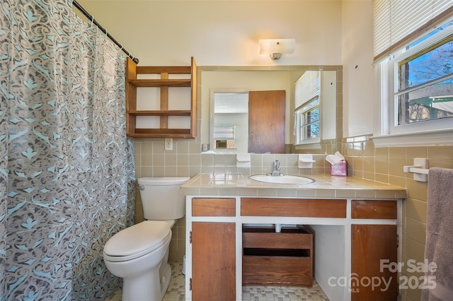 bathroom with tile walls, vanity, toilet, and a shower with shower curtain