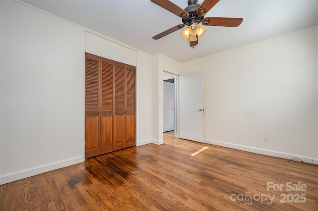 unfurnished bedroom featuring dark hardwood / wood-style flooring, a closet, and ceiling fan