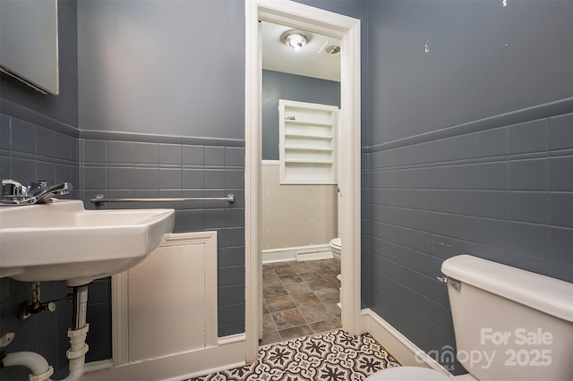 bathroom with tile walls and toilet