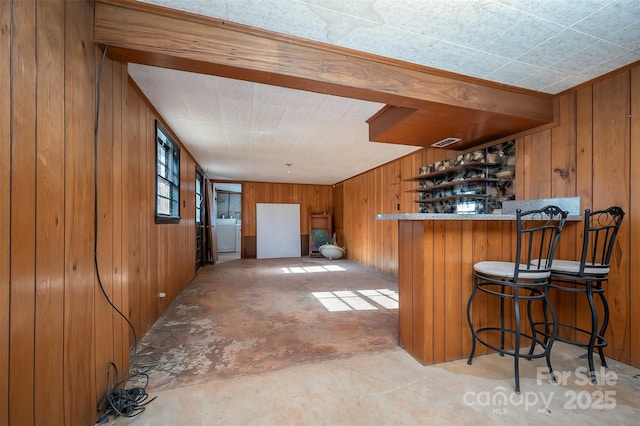 bar featuring wooden walls and washer / clothes dryer