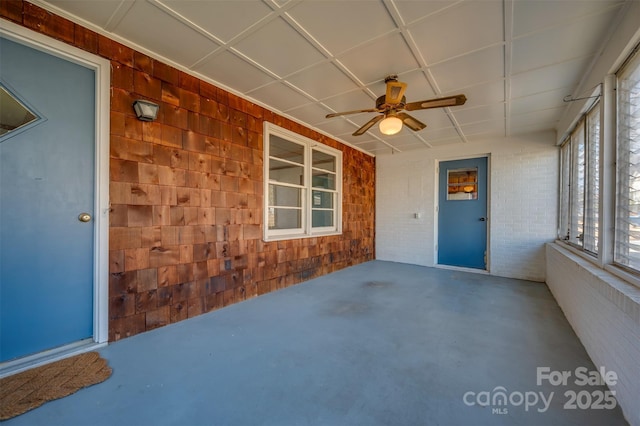 unfurnished sunroom with ceiling fan