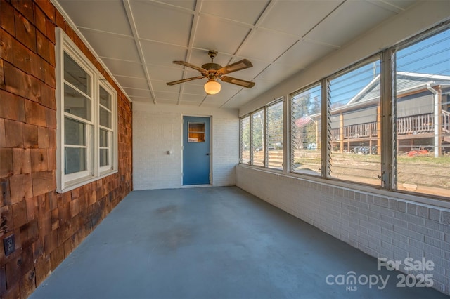 unfurnished sunroom with ceiling fan