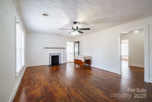 unfurnished living room featuring ornamental molding, dark wood-type flooring, and a wealth of natural light