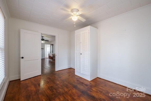 empty room with dark wood-type flooring, ceiling fan, and ornamental molding