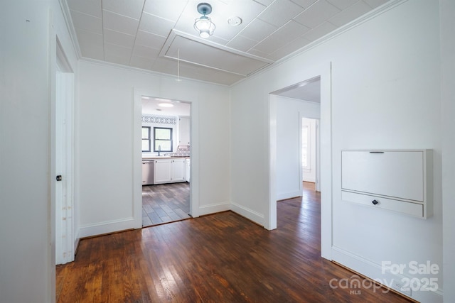 empty room with dark wood-type flooring and crown molding