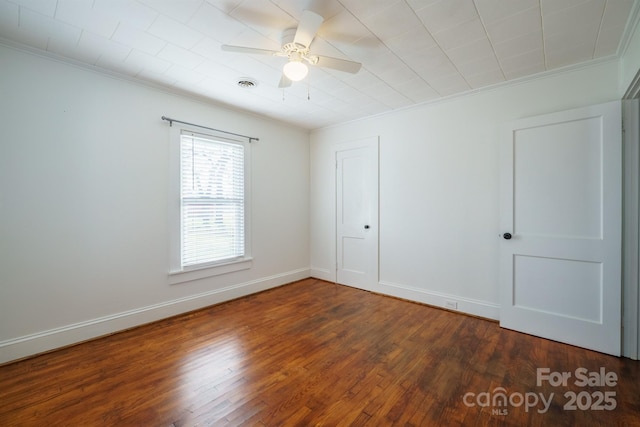 empty room featuring crown molding, ceiling fan, and dark hardwood / wood-style flooring