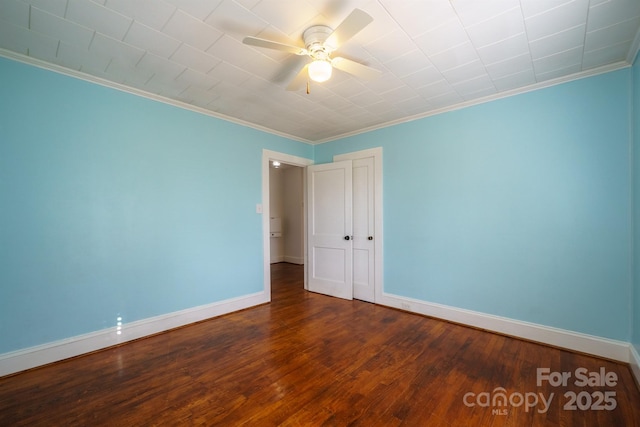 unfurnished room featuring dark hardwood / wood-style flooring, ornamental molding, and ceiling fan