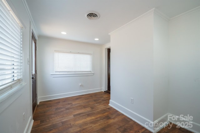 empty room with ornamental molding and dark hardwood / wood-style flooring