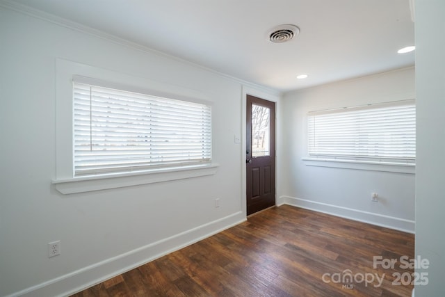 entrance foyer featuring dark wood-type flooring and crown molding