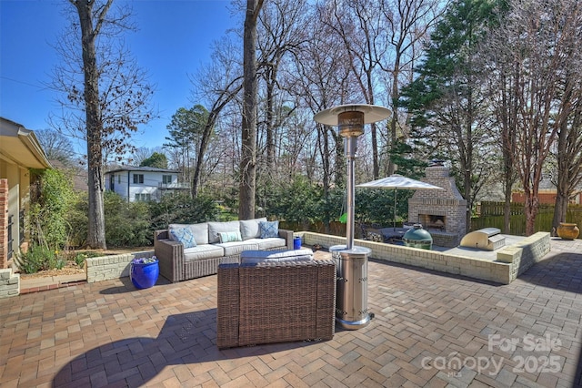 view of patio featuring an outdoor living space with a fireplace, fence, and exterior kitchen