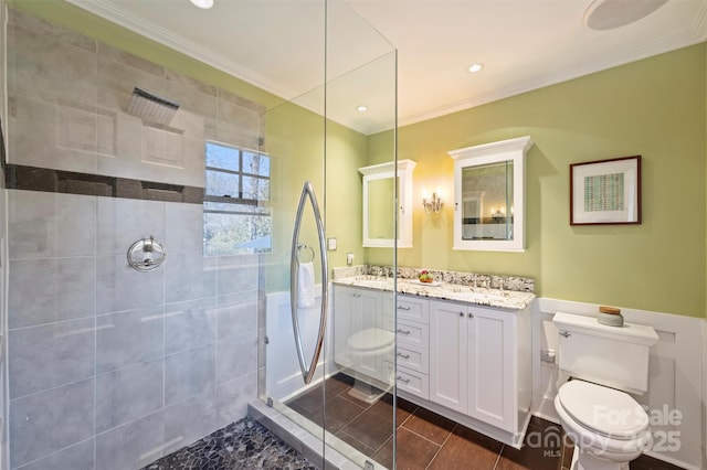 bathroom with toilet, a shower stall, ornamental molding, and vanity