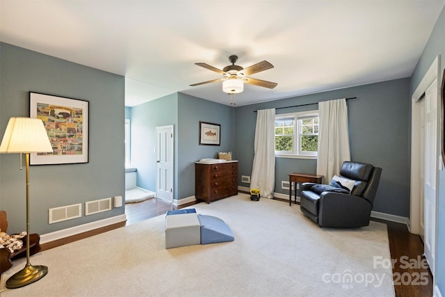 sitting room featuring baseboards, visible vents, and ceiling fan