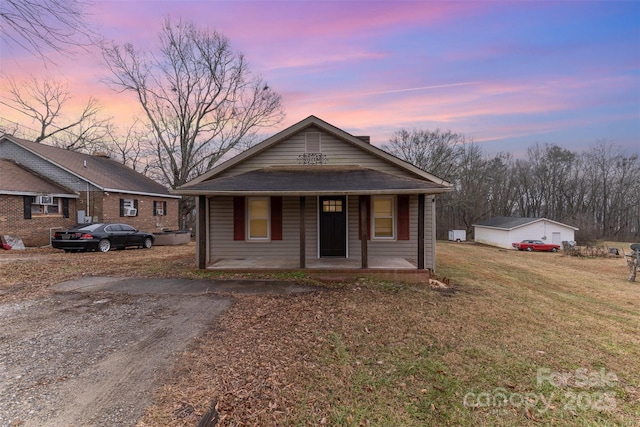 view of front of home featuring a porch, a garage, and a lawn