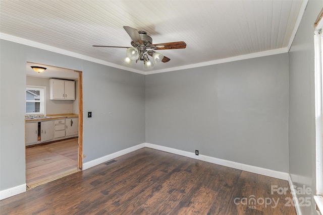 empty room with ornamental molding, dark hardwood / wood-style floors, and ceiling fan