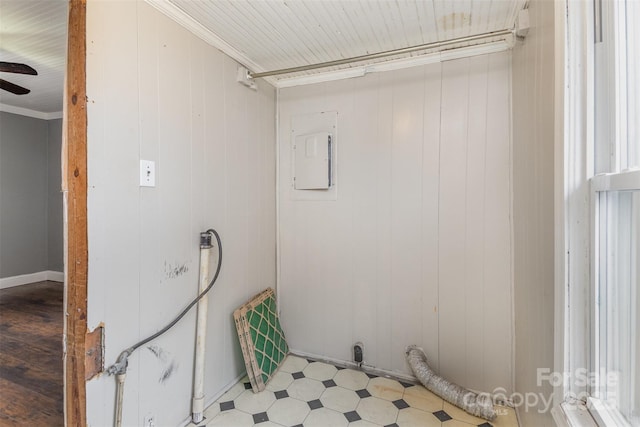 clothes washing area featuring crown molding, ceiling fan, and wooden walls