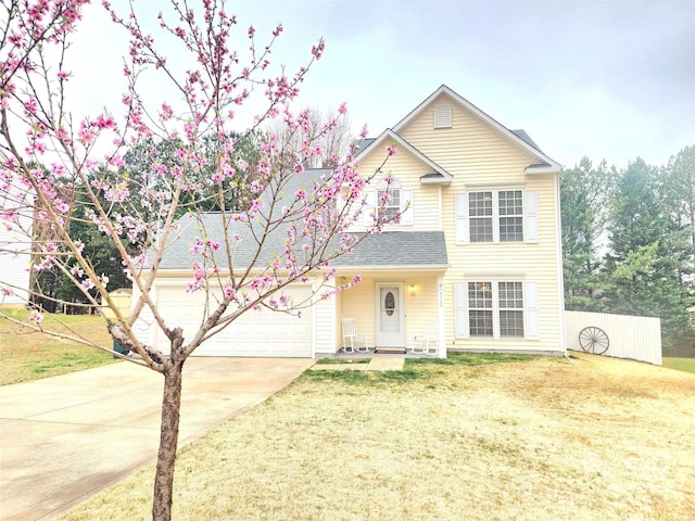 traditional home featuring a garage, roof with shingles, concrete driveway, and a front lawn