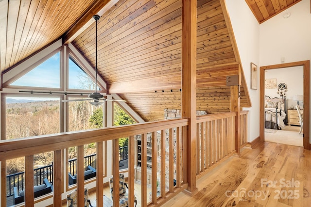 corridor featuring beam ceiling, light hardwood / wood-style floors, high vaulted ceiling, and wooden ceiling