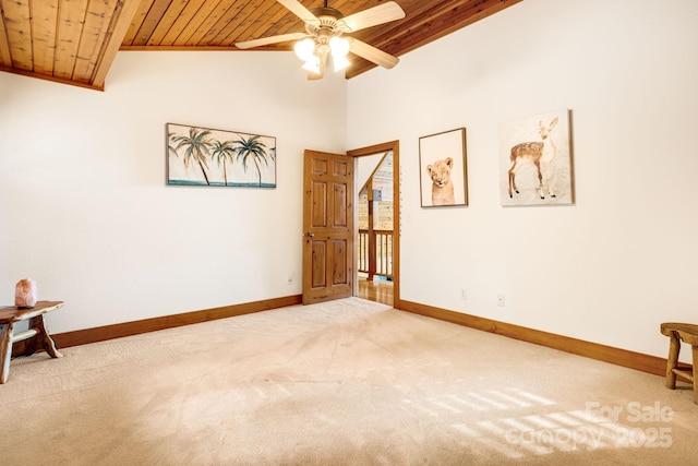 carpeted empty room featuring lofted ceiling, wooden ceiling, and ceiling fan