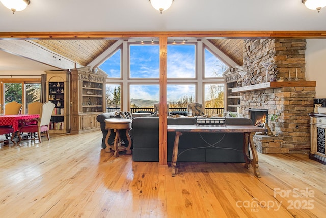 living area with beamed ceiling, hardwood / wood-style flooring, wooden ceiling, and a fireplace