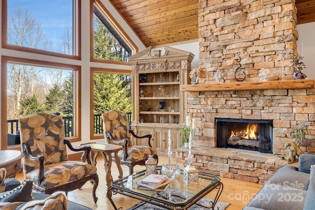living room featuring wooden ceiling, wood finished floors, high vaulted ceiling, and a fireplace