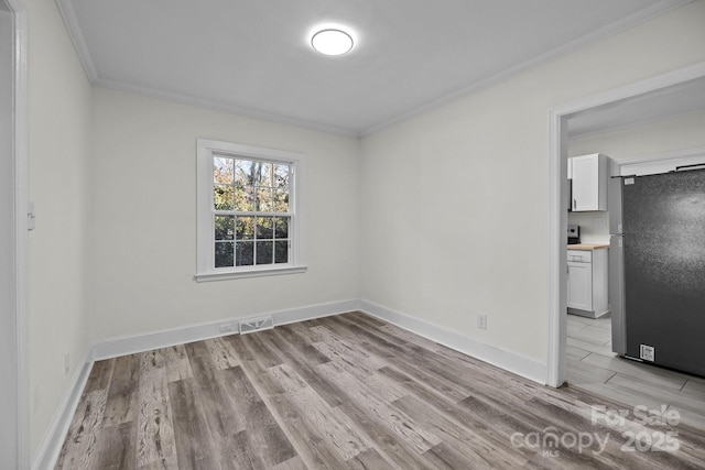 unfurnished room featuring light hardwood / wood-style flooring and ornamental molding