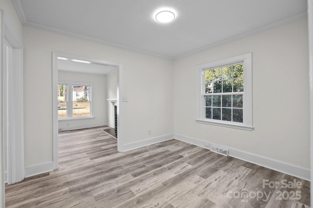 unfurnished room with crown molding and light hardwood / wood-style floors