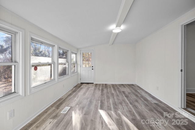 empty room with lofted ceiling with beams and light wood-type flooring