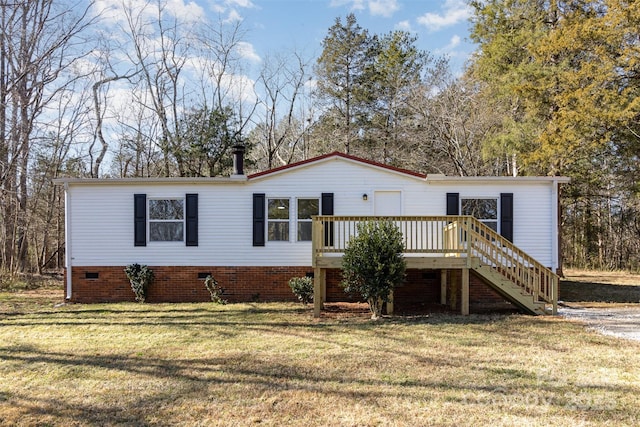 manufactured / mobile home with a wooden deck and a front lawn