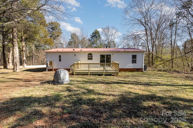 back of property featuring a wooden deck and a lawn