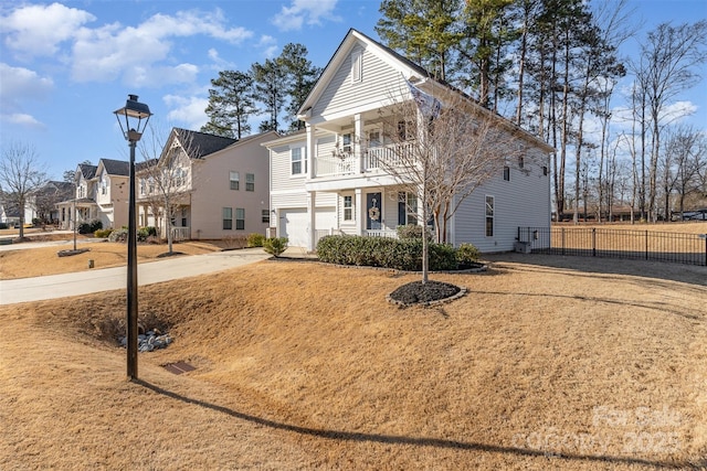 view of front of house featuring a balcony, a garage, and a front lawn