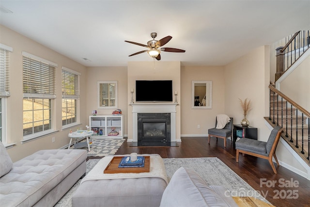 living room featuring dark wood-type flooring and ceiling fan