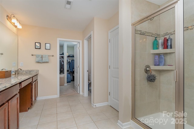 bathroom featuring vanity, tile patterned floors, and walk in shower