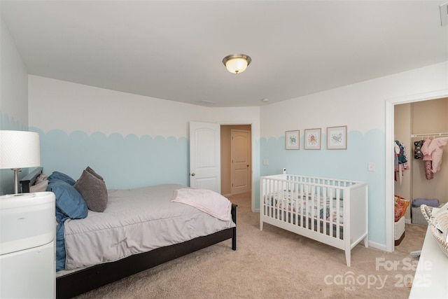 carpeted bedroom with a spacious closet and a closet