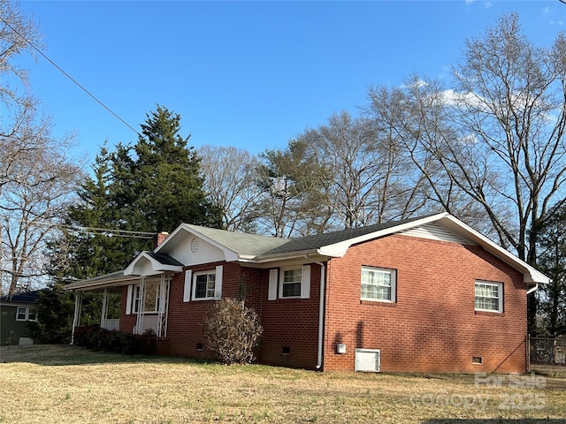 view of home's exterior with covered porch and a lawn