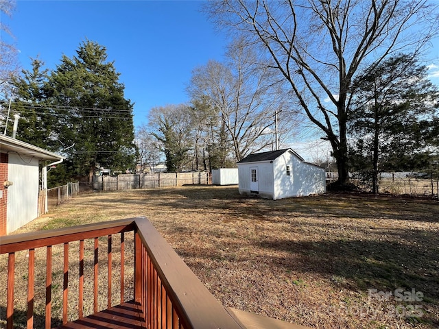 view of yard featuring a storage unit and a deck