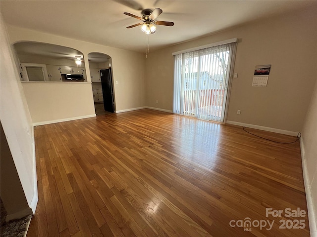 unfurnished living room with dark wood-type flooring and ceiling fan