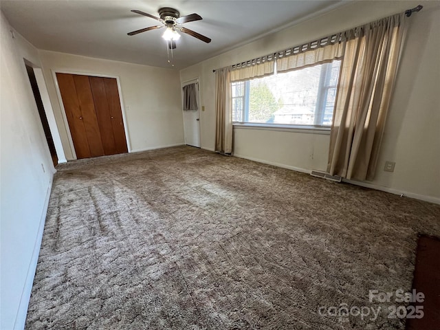 unfurnished bedroom featuring carpet floors, ceiling fan, and a closet